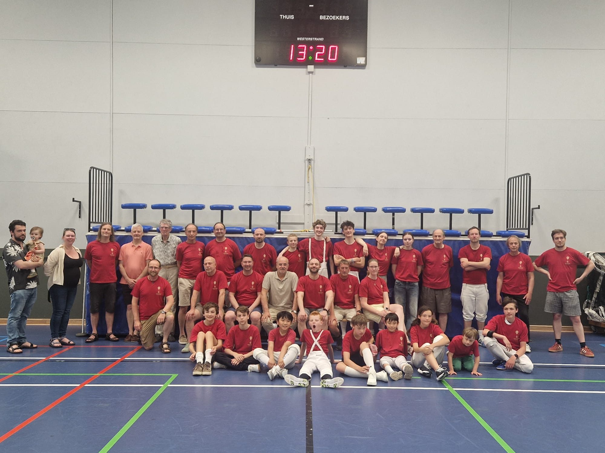 Groepsfoto van de leden van Omnisword in de sporthal, met de beker vooraan.